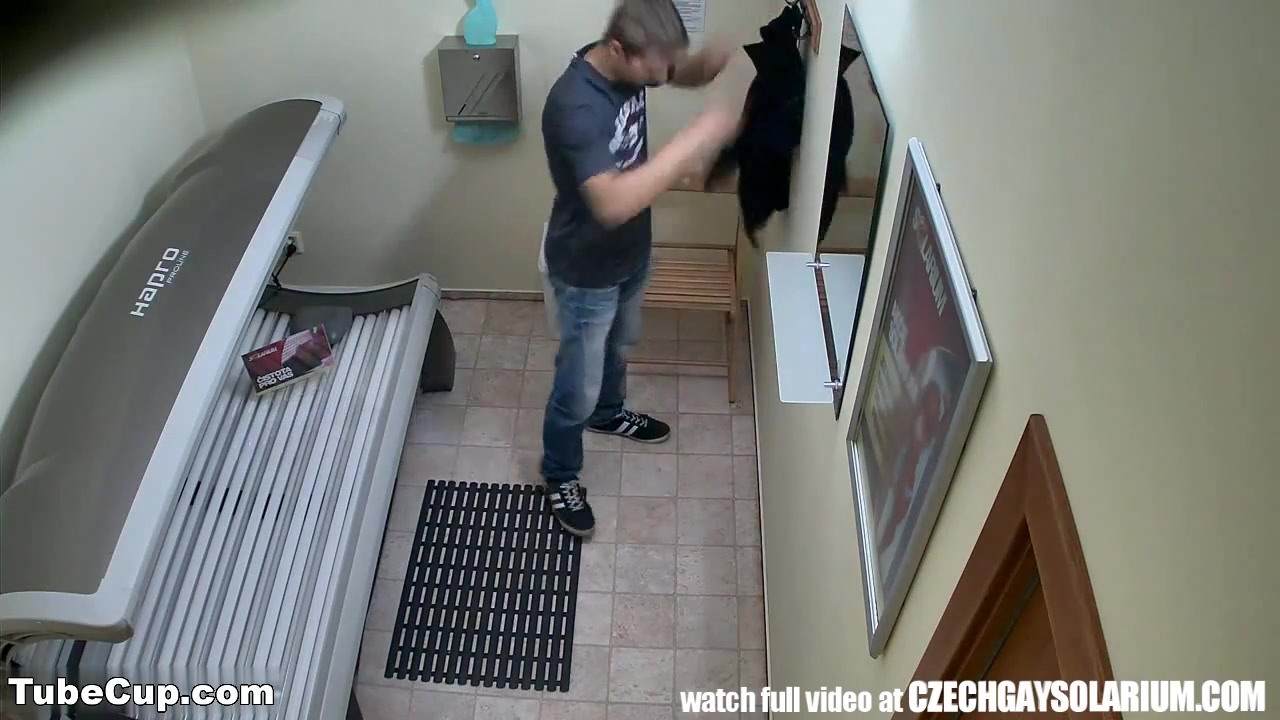 Handsome young man filmed secret camera in public solarium